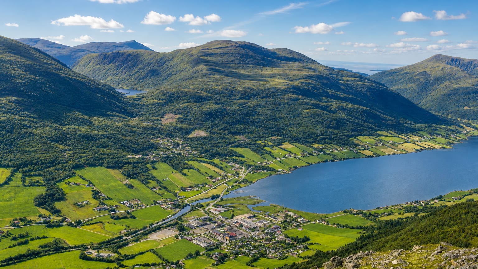 Batnfjordsøra at the head of Batnfjorden, surrounded by green farmland and forested mountains, Møre og Romsdal, Norway