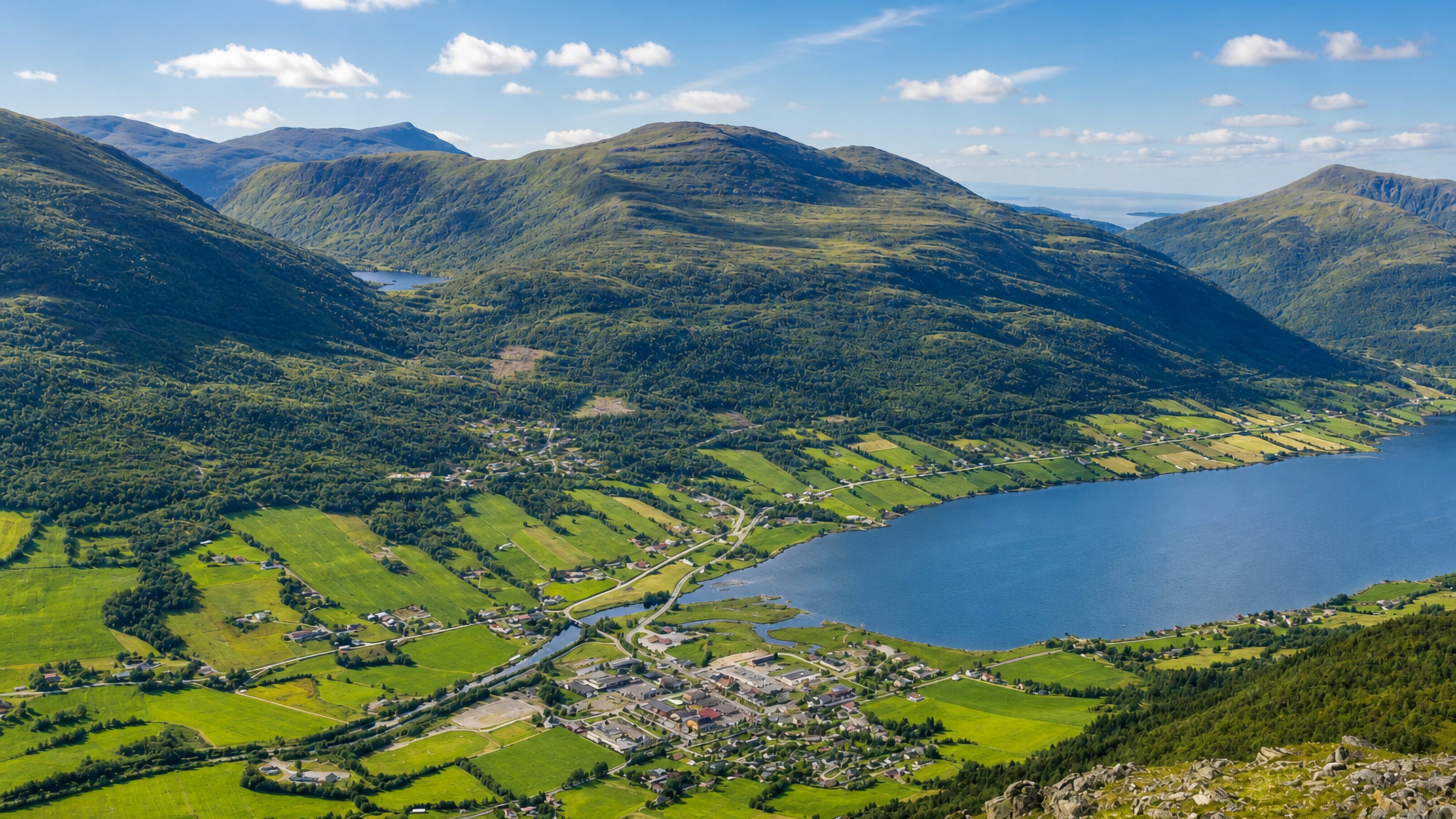Batnfjordsøra at the head of Batnfjorden, surrounded by green farmland and forested mountains, Møre og Romsdal, Norway