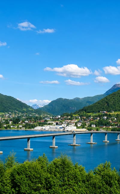 The Sykkylven bridge spanning the fjord to the waterfront village below green mountains