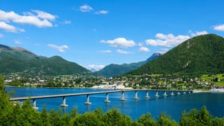 The Sykkylven bridge spanning the fjord to the waterfront village below green mountains