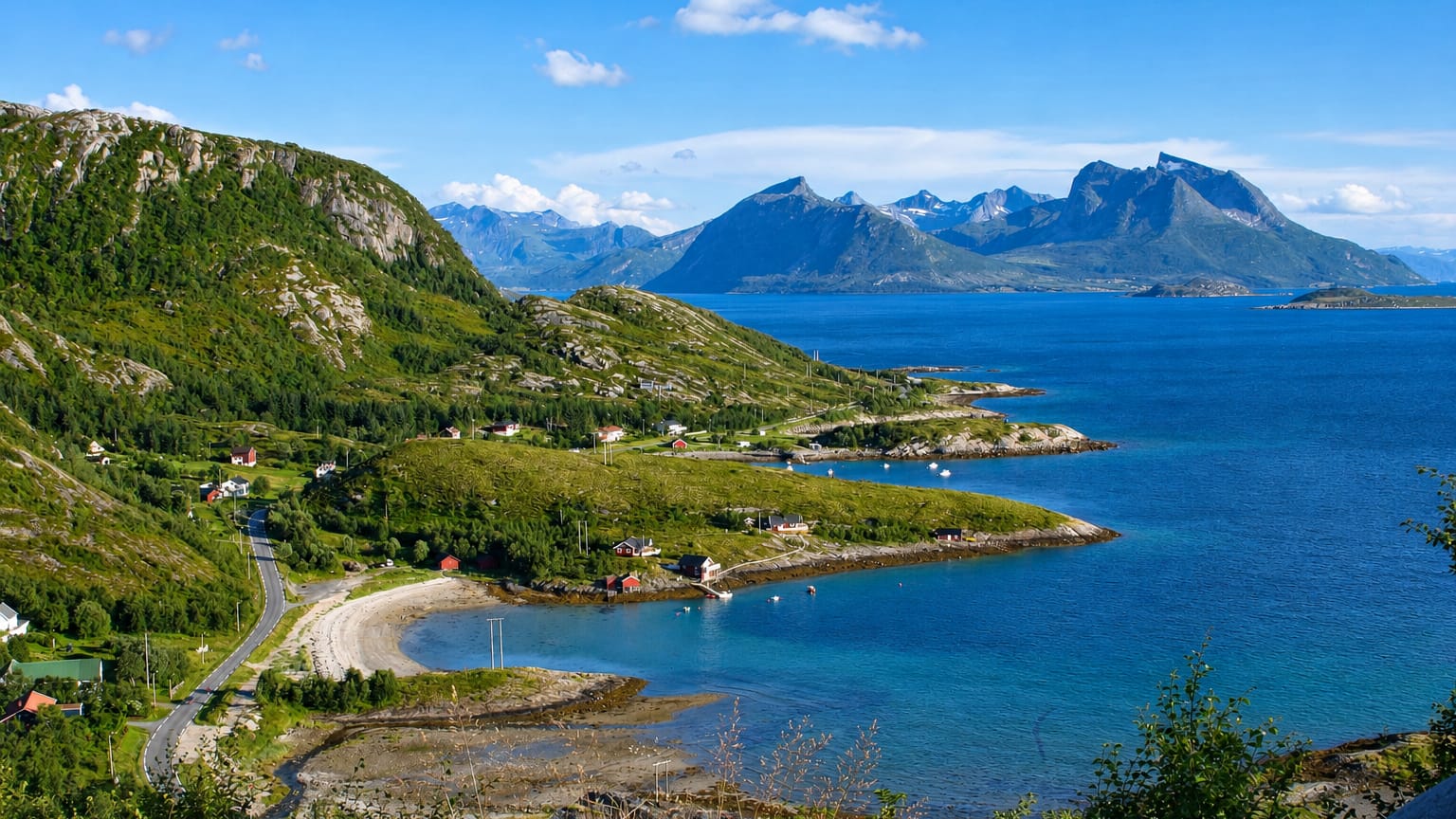 Lurøy's green coastal mountains, scattered red and white houses, and a winding road above a blue fjord in Nordland, Norway.