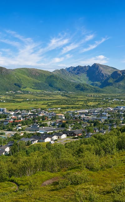 Elevated view of Myre town set below the dramatic Vesterålen mountains, Norway