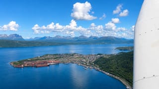 Aerial view of Narvik, Norway, its iron-ore harbour and peninsula reaching into the fjord below snow-flecked mountains.