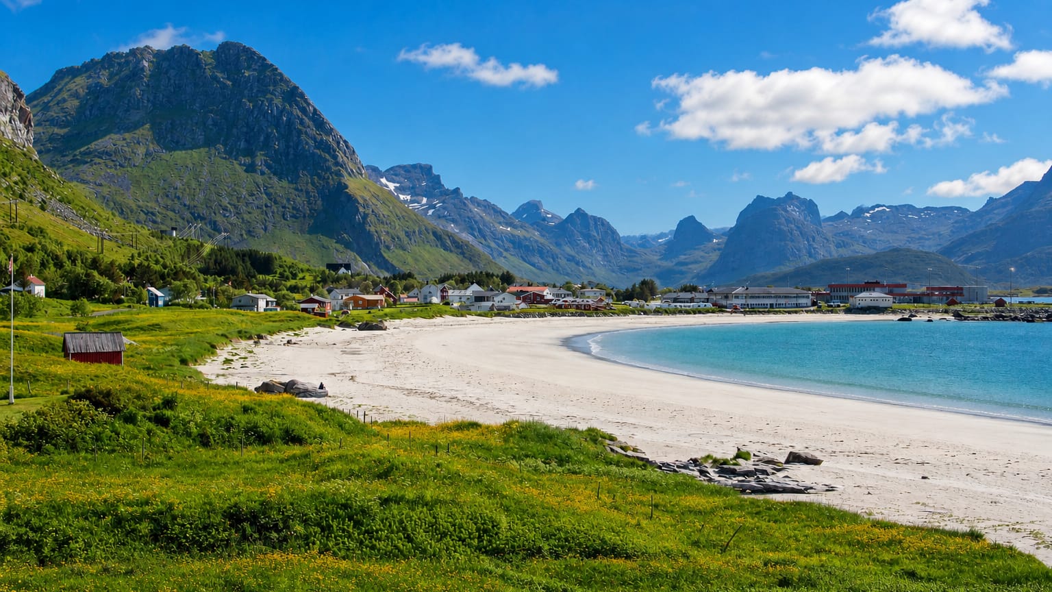 White-sand beach and turquoise bay at Ramberg backed by dramatic Lofoten mountains, Norway