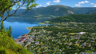 View over Rognan, Norway, at the head of a fjord ringed by green valleys and mountains