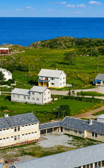 The small coastal settlement of Solfjellsjoen on the Helgeland coast of Nordland, Norway, with scattered houses beside the sea.