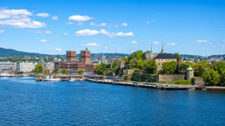 Oslo waterfront with the twin-towered City Hall and Akershus Fortress along the blue Oslofjord