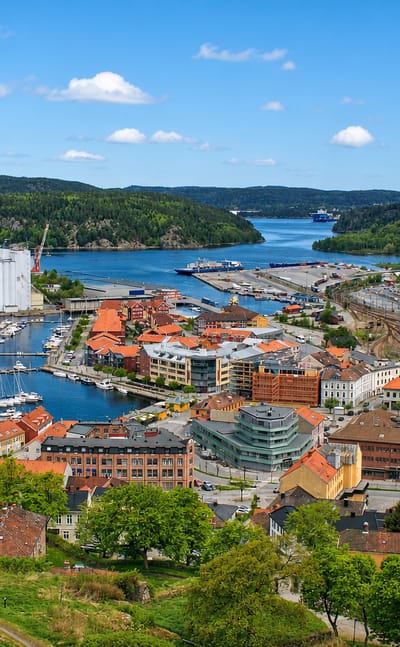 Aerial view of Halden, Norway, with red-roofed old town, harbour, grain silos and the fjord beyond.