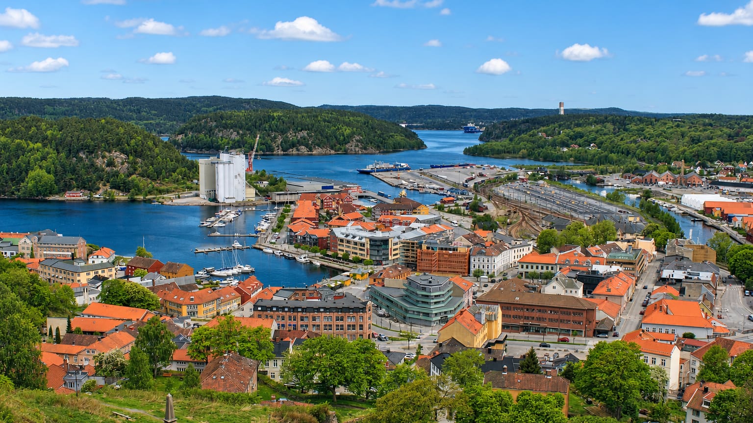 Aerial view of Halden, Norway, with red-roofed old town, harbour, grain silos and the fjord beyond.