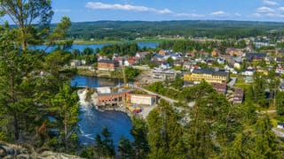 Elevated view of Ørje with its river dam, colourful timber houses and lake amid Østfold's forests.
