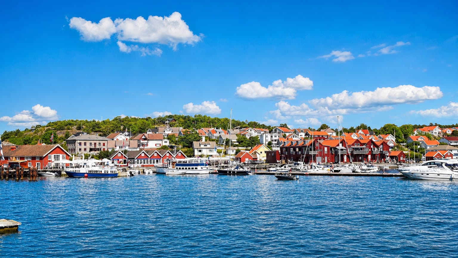 Red harbour houses and moored boats at Skjaerhalden, Norway, on the Hvaler archipelago
