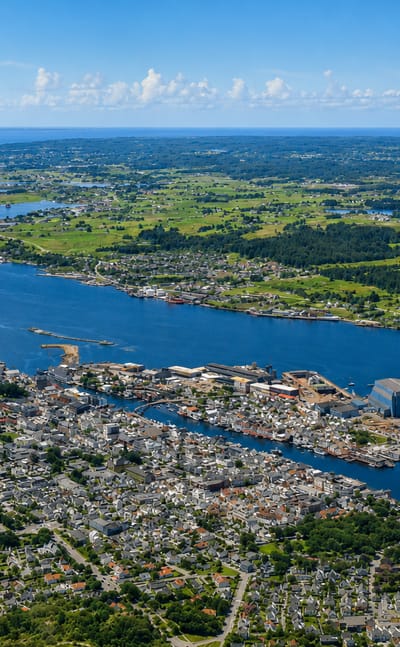 Aerial view of Haugesund straddling the Karmsund strait, with harbour, marinas and residential districts under a summer sky