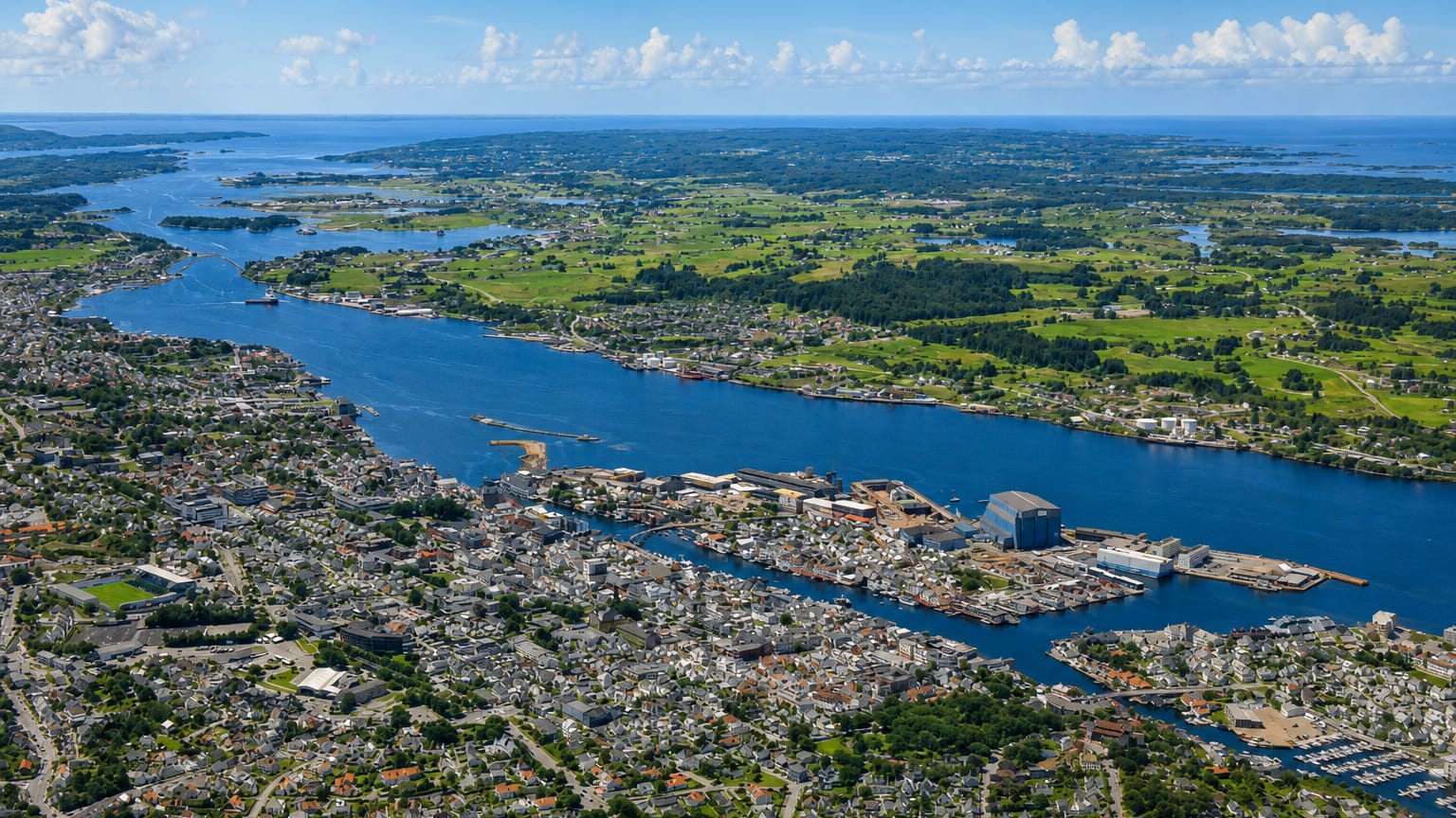 Aerial view of Haugesund straddling the Karmsund strait, with harbour, marinas and residential districts under a summer sky