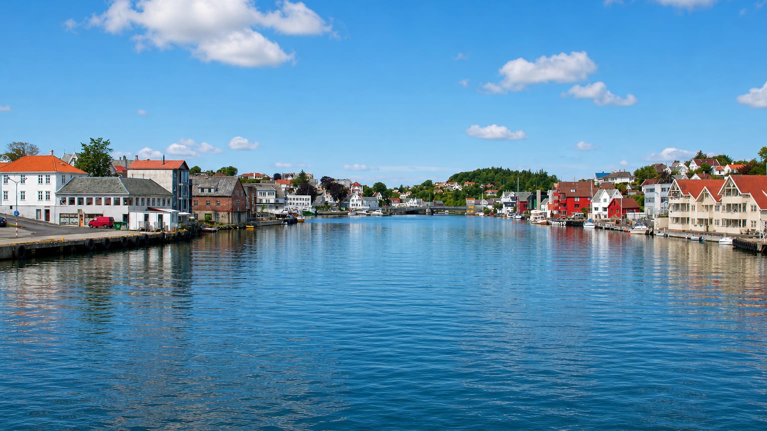 Kopervik harbour channel in Norway lined with white and red timber houses reflected in calm water