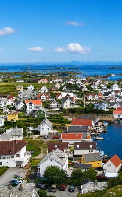 Aerial view of Ydstebøhamn on Kvitsøy, Norway, white and red wooden houses around a harbour among low skerries