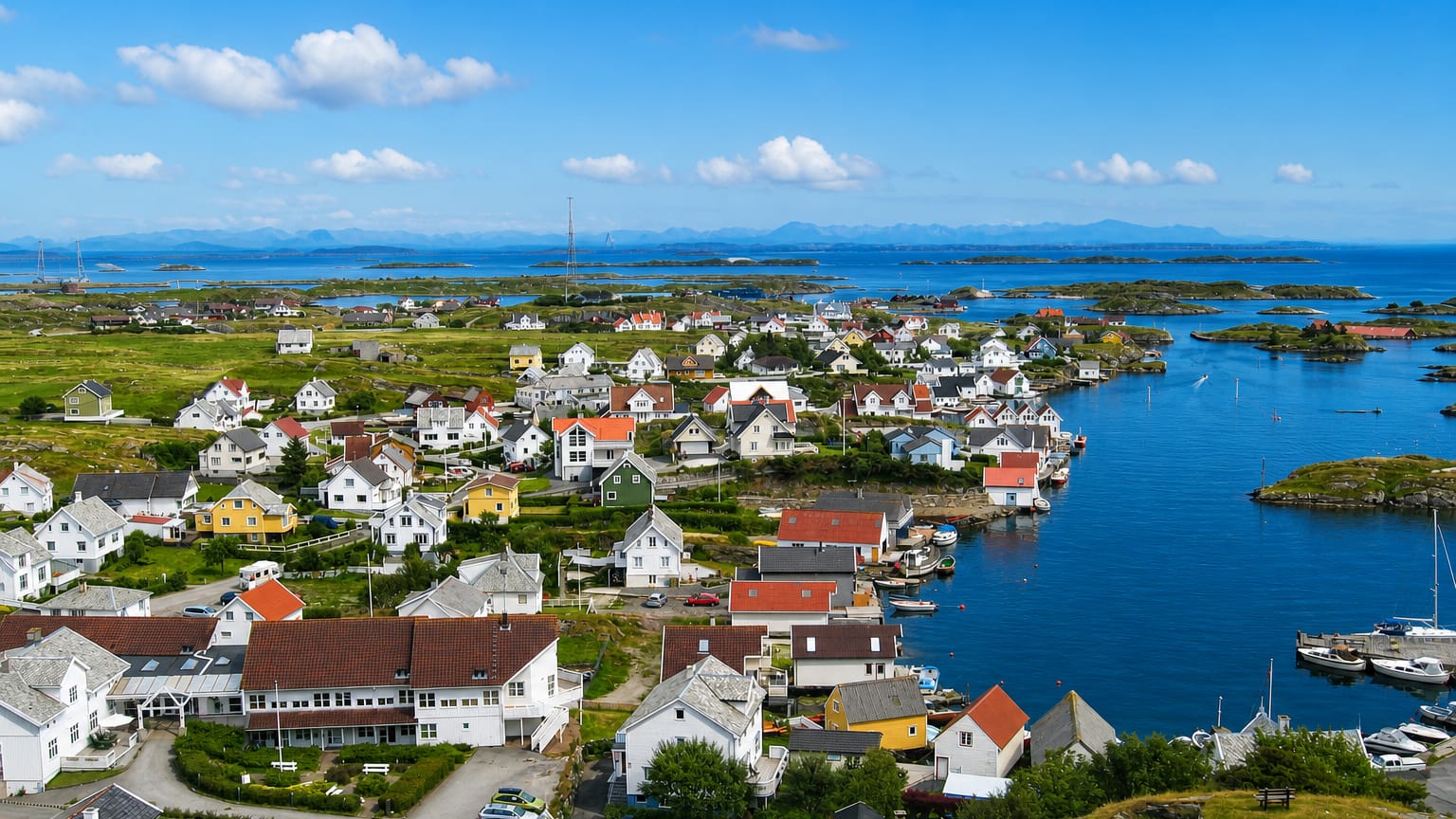 Aerial view of Ydstebøhamn on Kvitsøy, Norway, white and red wooden houses around a harbour among low skerries