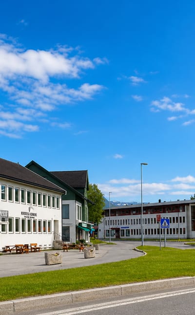 Storslett town centre with the Nordreisa municipality hall and Rådhus below distant mountains, Norway.