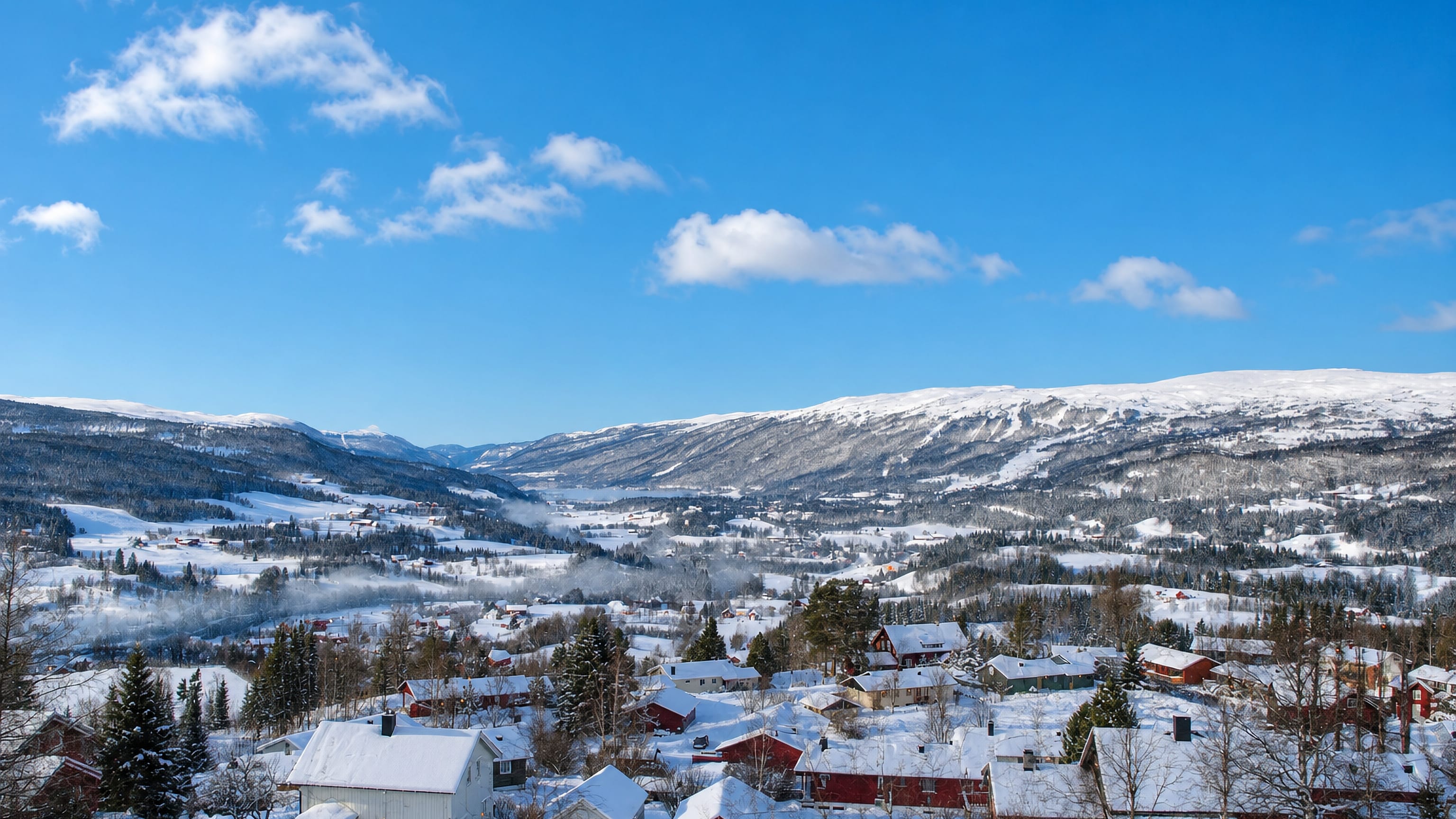 Snow-covered houses and forest in the mountain valley of Meråker, Trøndelag, Norway, under a blue winter sky