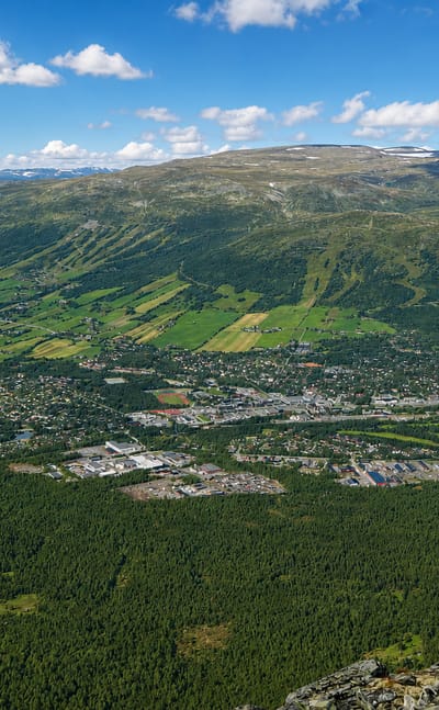 Aerial view of Oppdal town in its valley with ski slopes and surrounding mountains, Norway