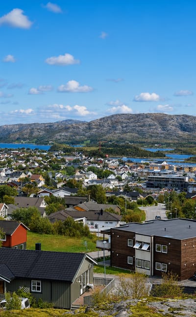 Coastal town of Rorvik, Norway, with its harbour, colourful houses and islands under a blue sky