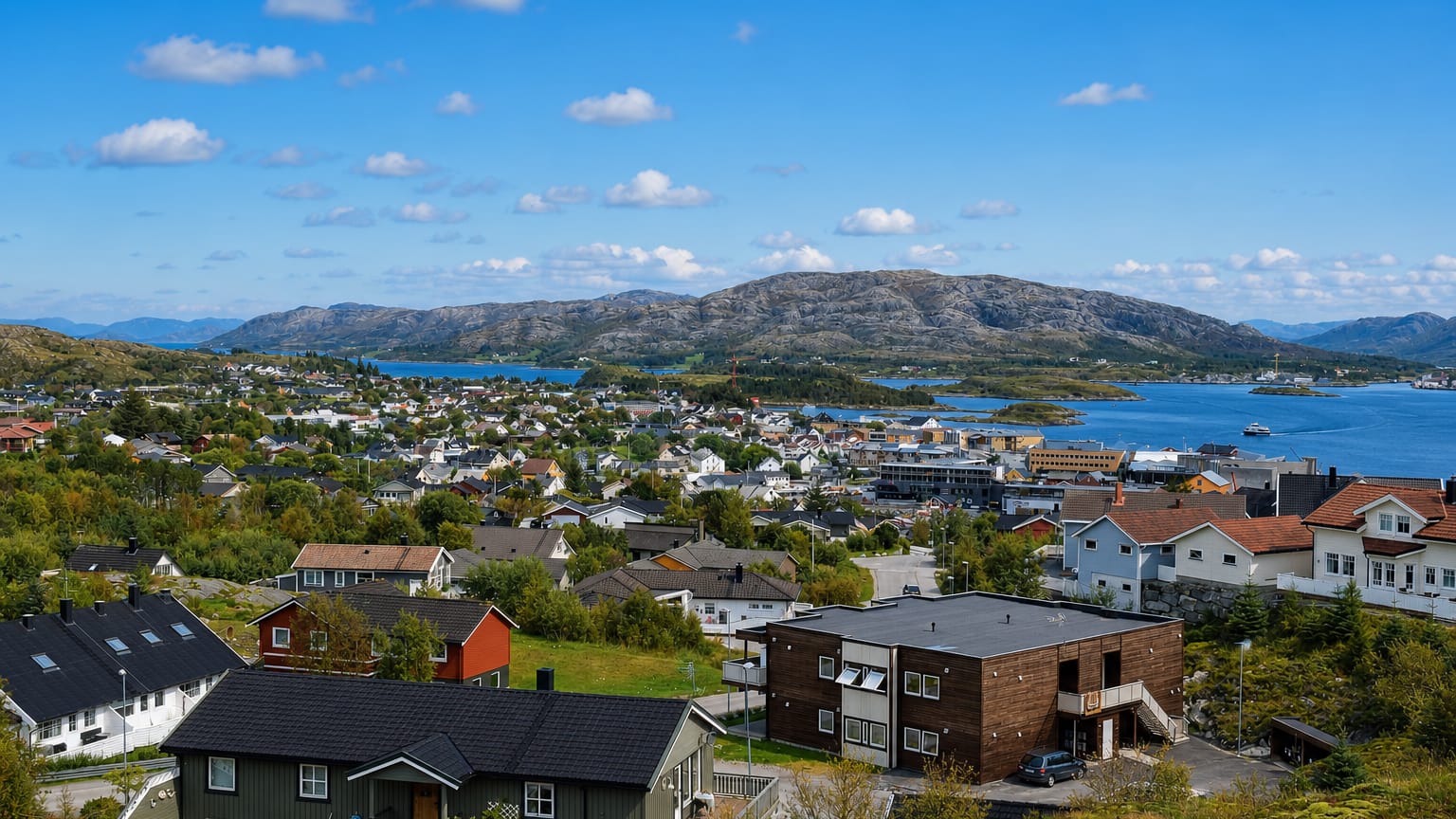 Coastal town of Rorvik, Norway, with its harbour, colourful houses and islands under a blue sky