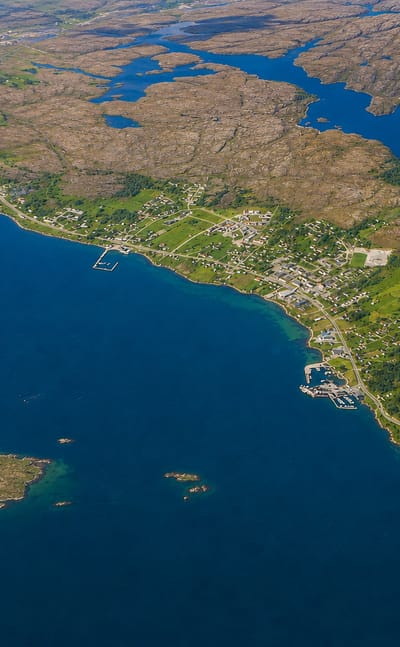 Aerial view of the island settlement of Sistranda, Norway, scattered across rocky coastal terrain among blue waters