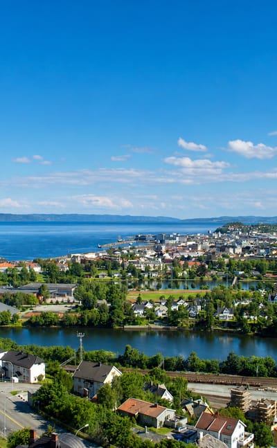Aerial view of Trondheim, Norway, with the Nidelva river bend curving toward the city and Trondheimsfjord
