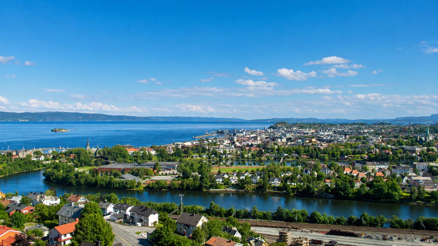 Aerial view of Trondheim, Norway, with the Nidelva river bend curving toward the city and Trondheimsfjord