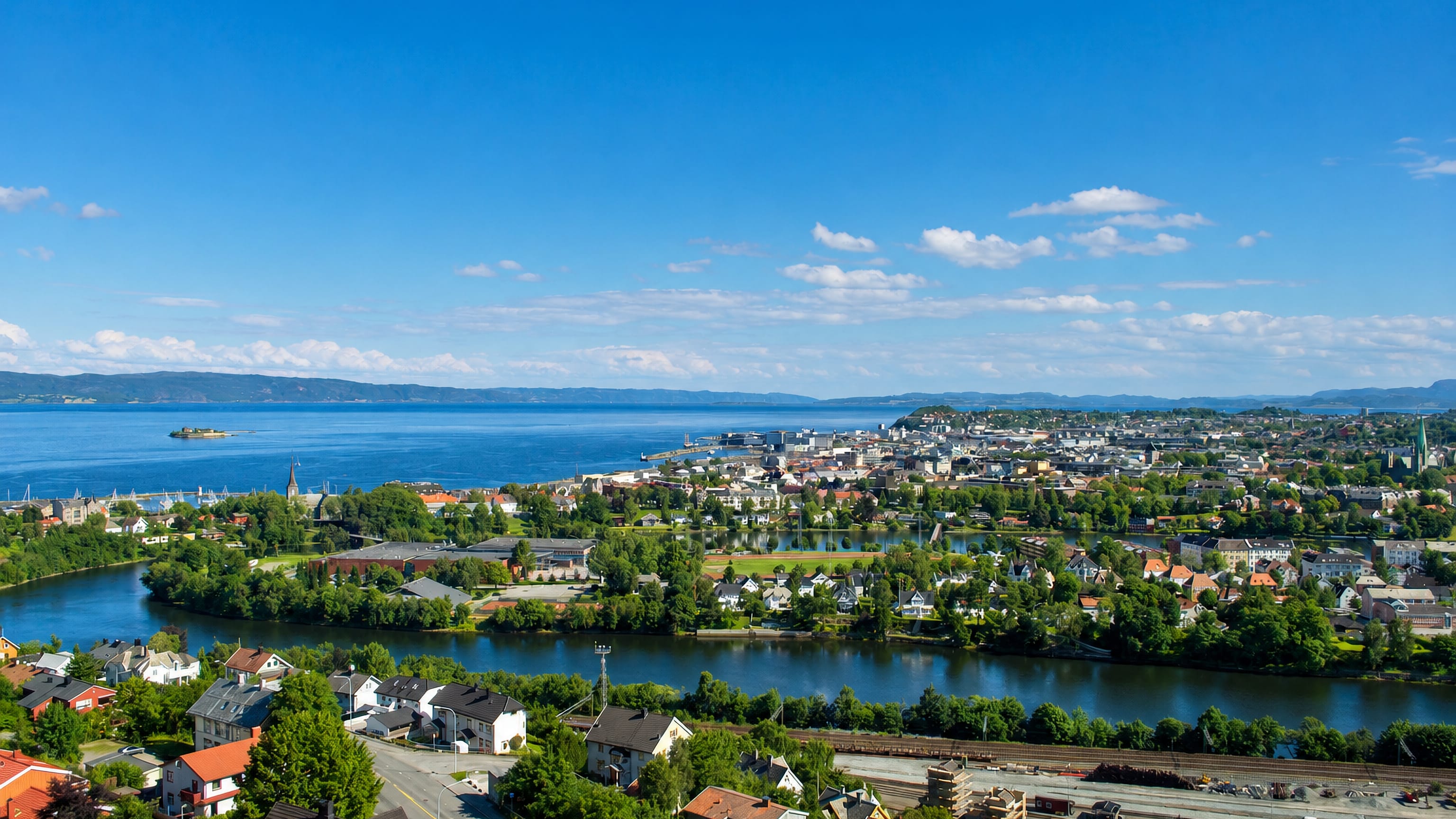 Aerial view of Trondheim, Norway, with the Nidelva river bend curving toward the city and Trondheimsfjord
