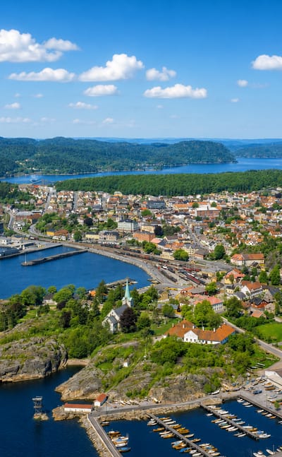 Aerial view of Larvik's harbour and town spread along the fjord with forested hills behind