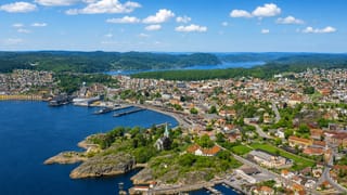 Aerial view of Larvik's harbour and town spread along the fjord with forested hills behind