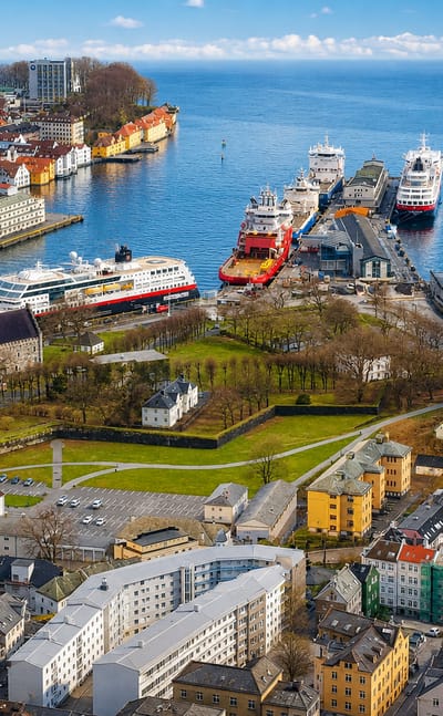 Aerial view of Bergenhus, Bergen — harbour with moored ships, green fortress grounds and colourful waterfront buildings.