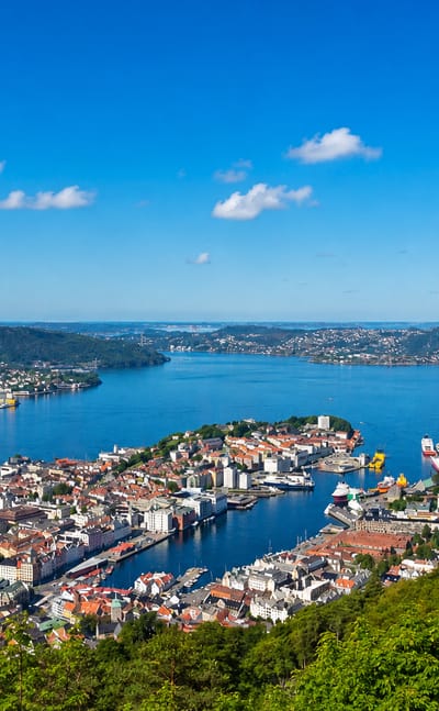 Elevated view over Bergen's Vagen harbour and old town ringed by fjords and mountains