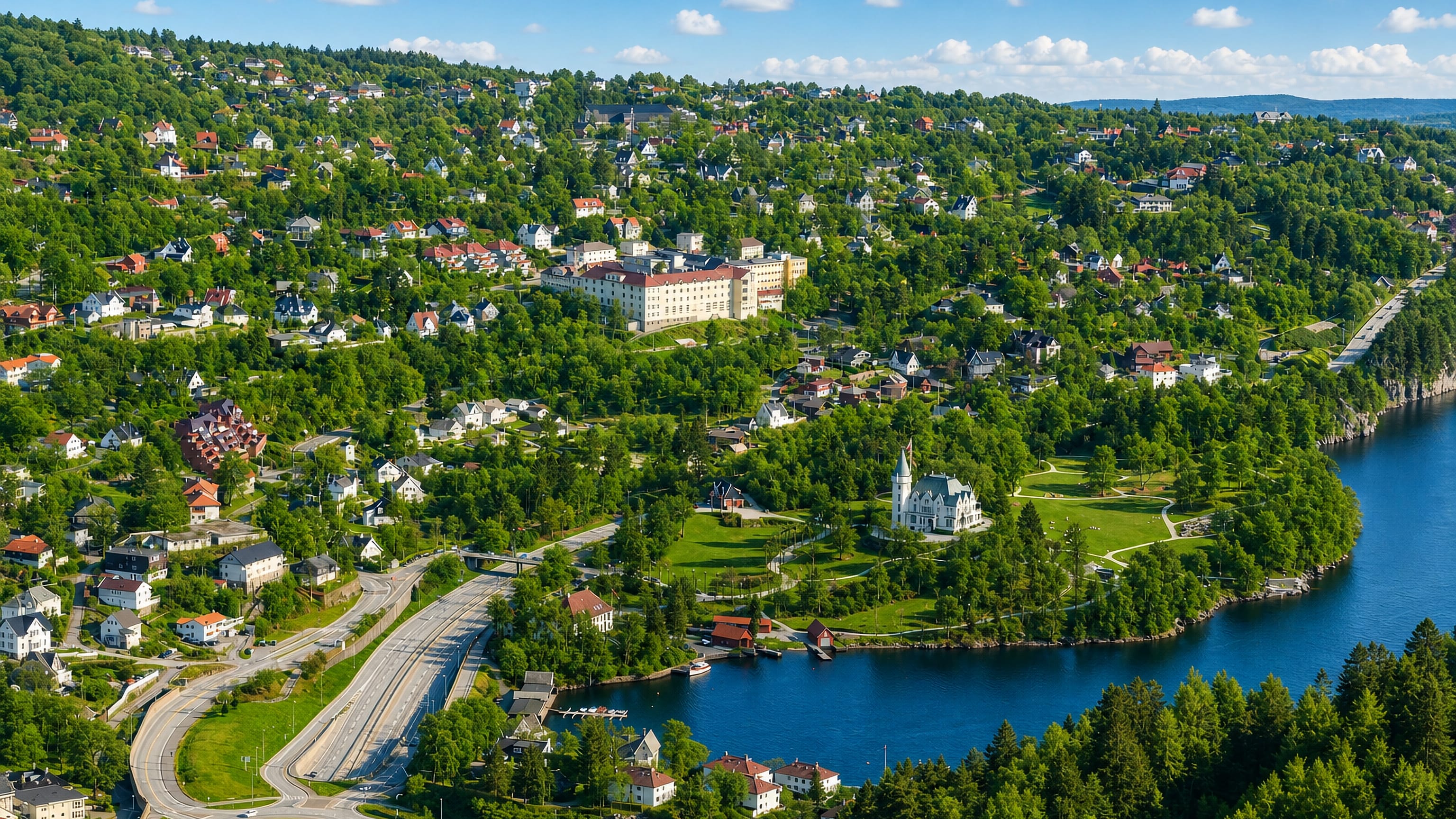 Aerial view of Fjøsanger, Bergen: wooded hillside houses, a white turreted manor in parkland and a fjord inlet.