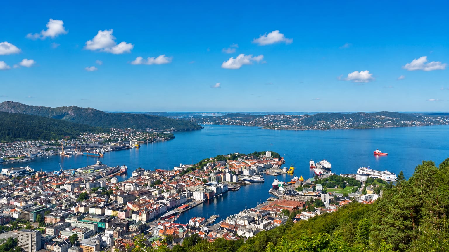 Elevated view over Bergen's Vagen harbour and old town ringed by fjords and mountains
