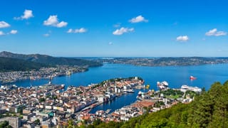 Elevated view over Bergen's Vagen harbour and old town ringed by fjords and mountains