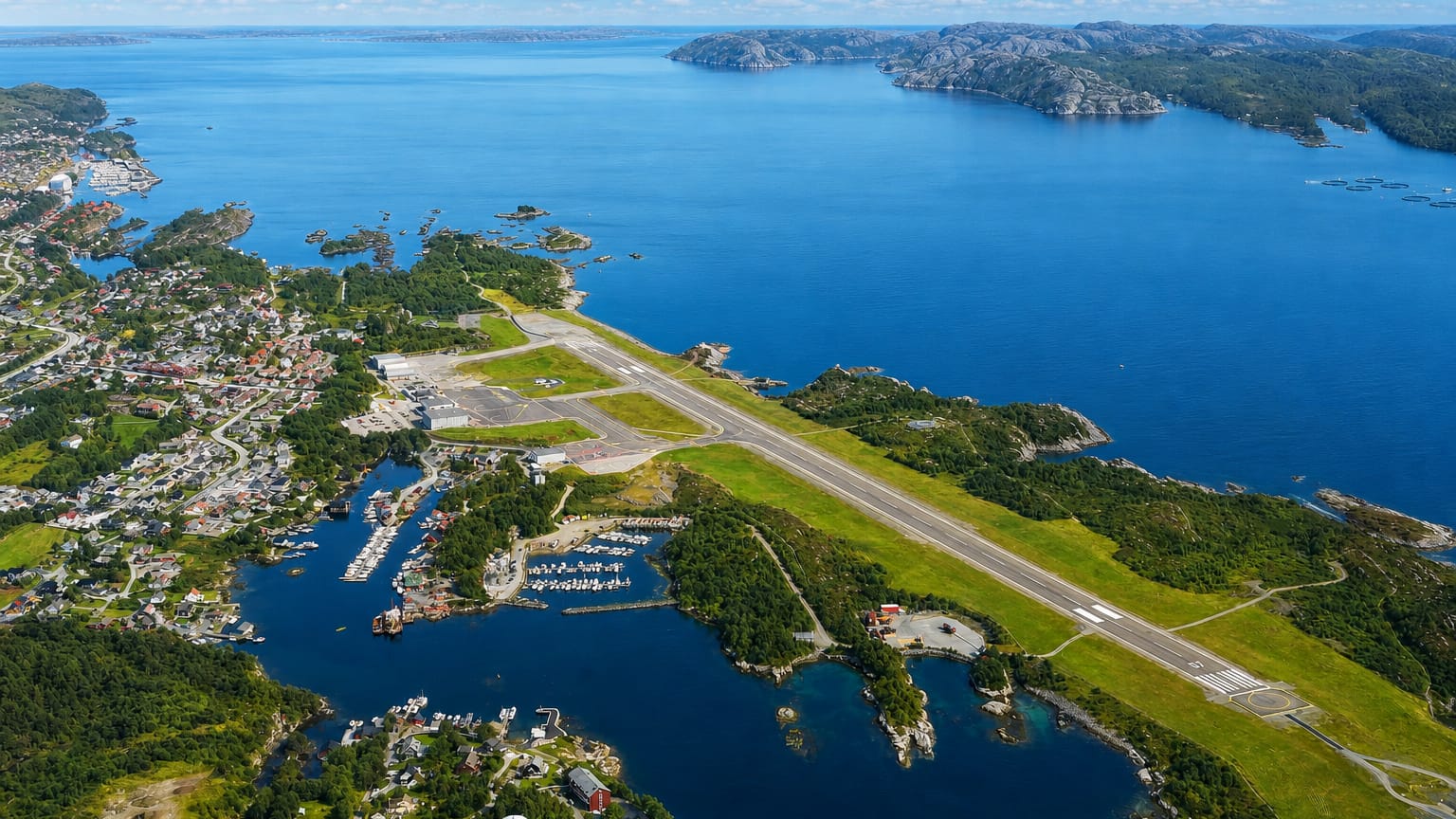 Aerial view of Floro on the Norwegian coast with its airport runway, harbour and skerry-dotted fjord.