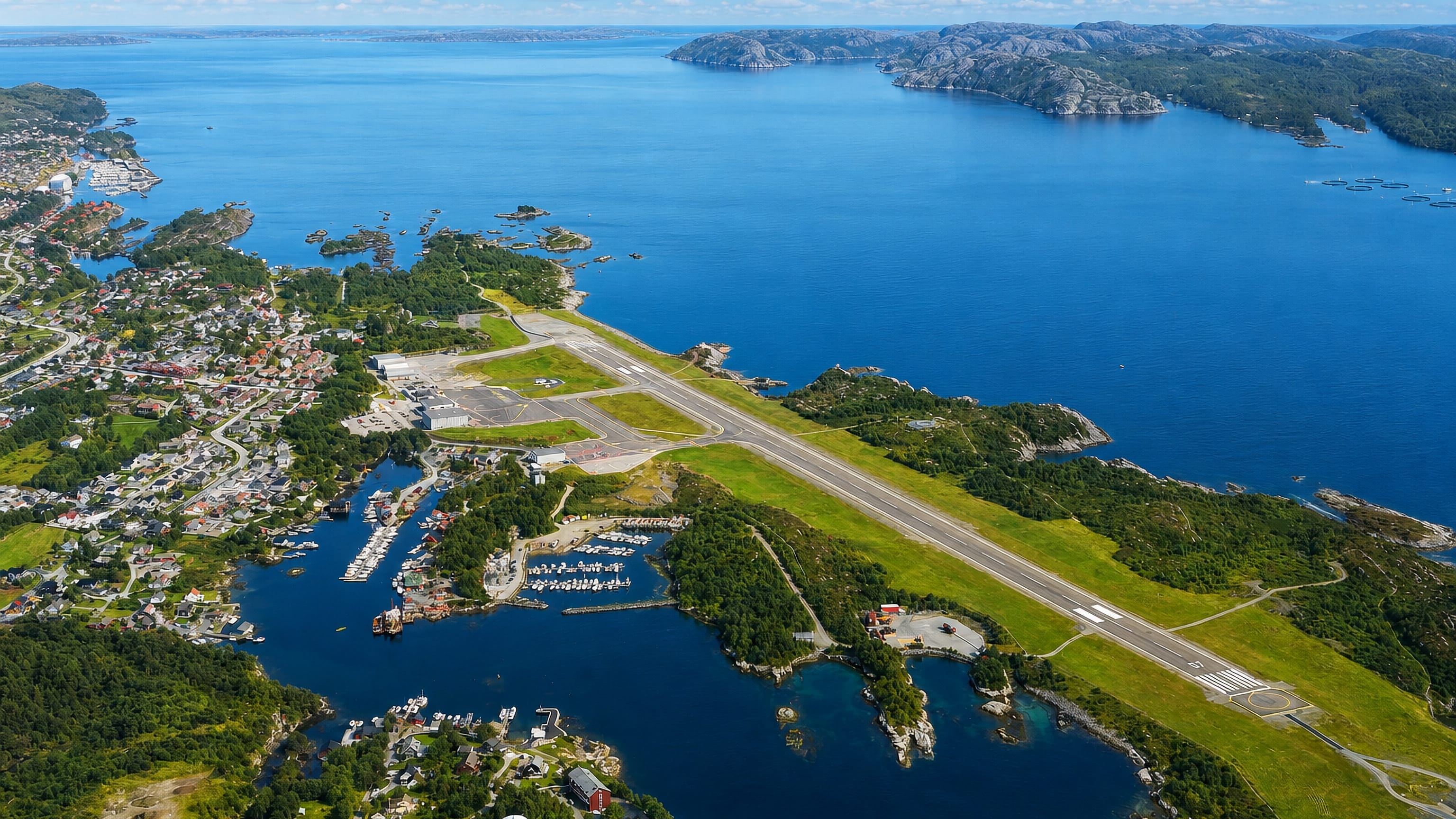 Aerial view of Floro on the Norwegian coast with its airport runway, harbour and skerry-dotted fjord.