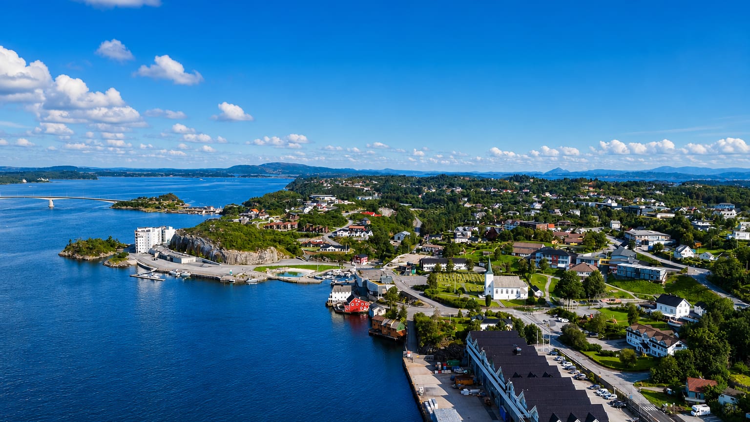 Aerial view of Storebo's harbour, white church and islet-dotted coast in Austevoll, Vestland, Norway.