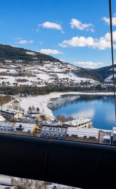 Winter view over Voss and Vangsvatnet lake from the Voss gondola, with snow-covered town and mountains.