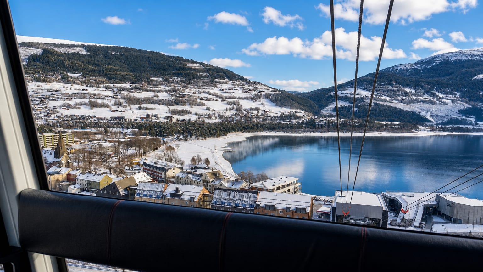 Winter view over Voss and Vangsvatnet lake from the Voss gondola, with snow-covered town and mountains.