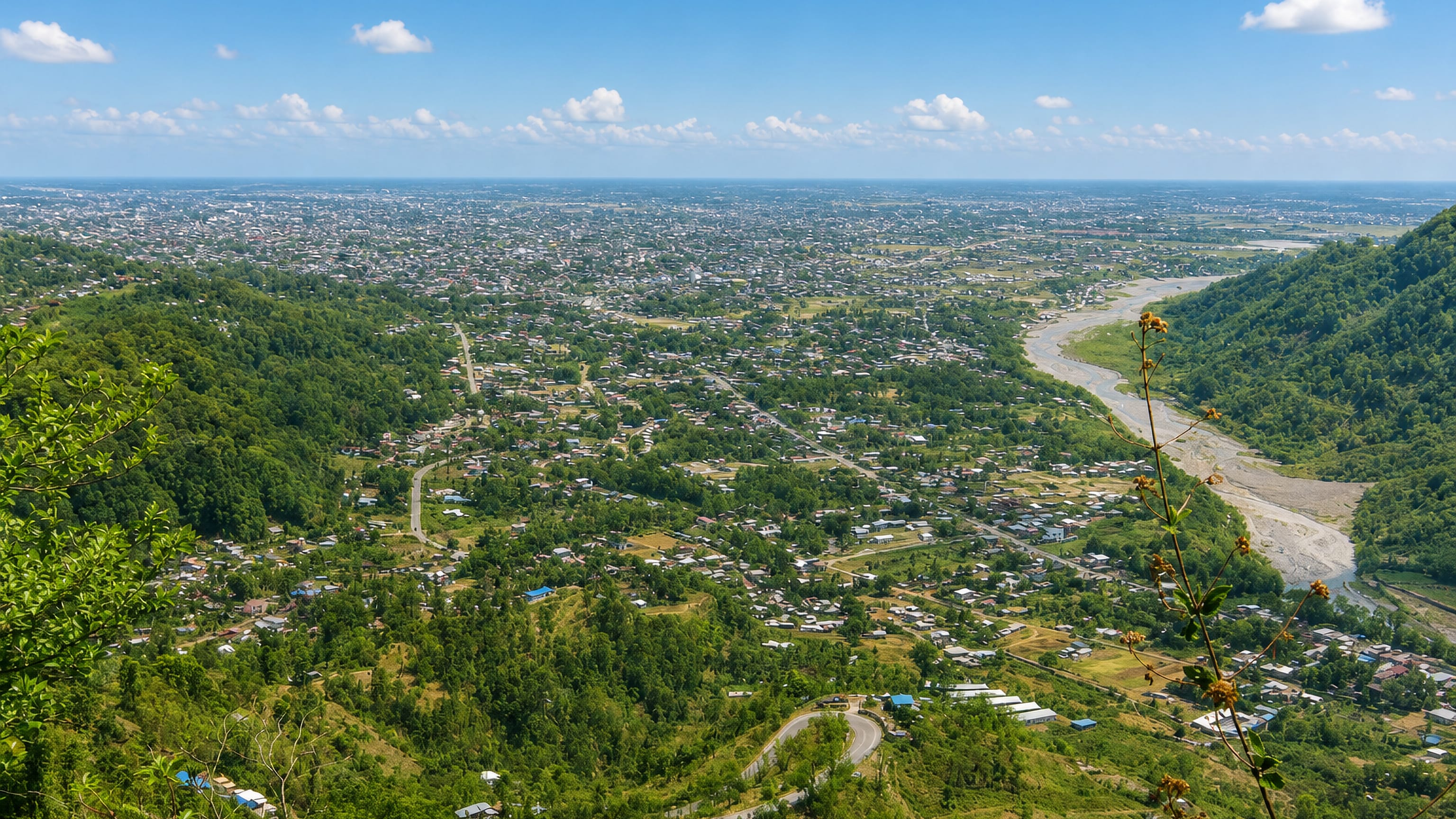 Dharan spreading from the wooded Siwalik foothills onto the Terai plain, a braided river along its eastern edge.