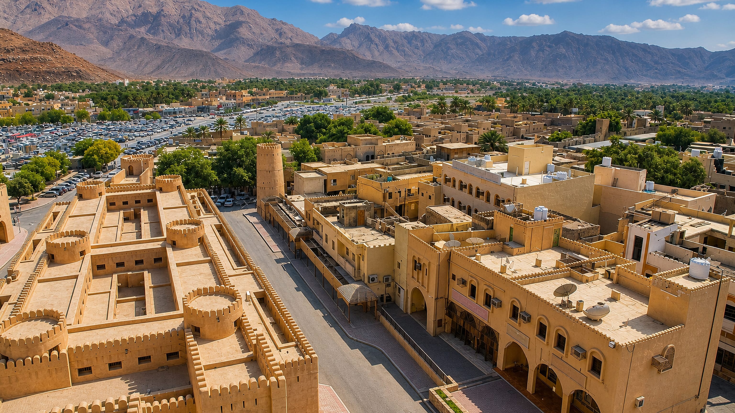 Nizwa's mud-brick fort and souq rooftops below the Hajar Mountains in interior Oman.