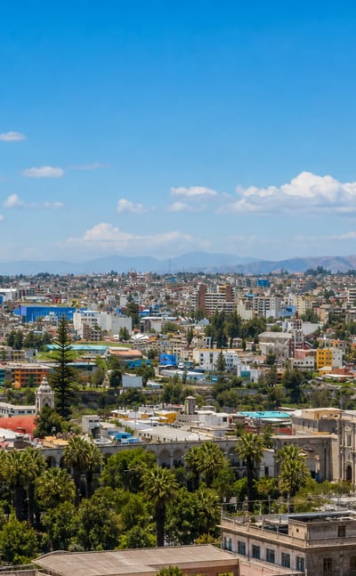 Skyline of Arequipa, Peru, with the twin-towered basilica cathedral and white buildings below the mountains.