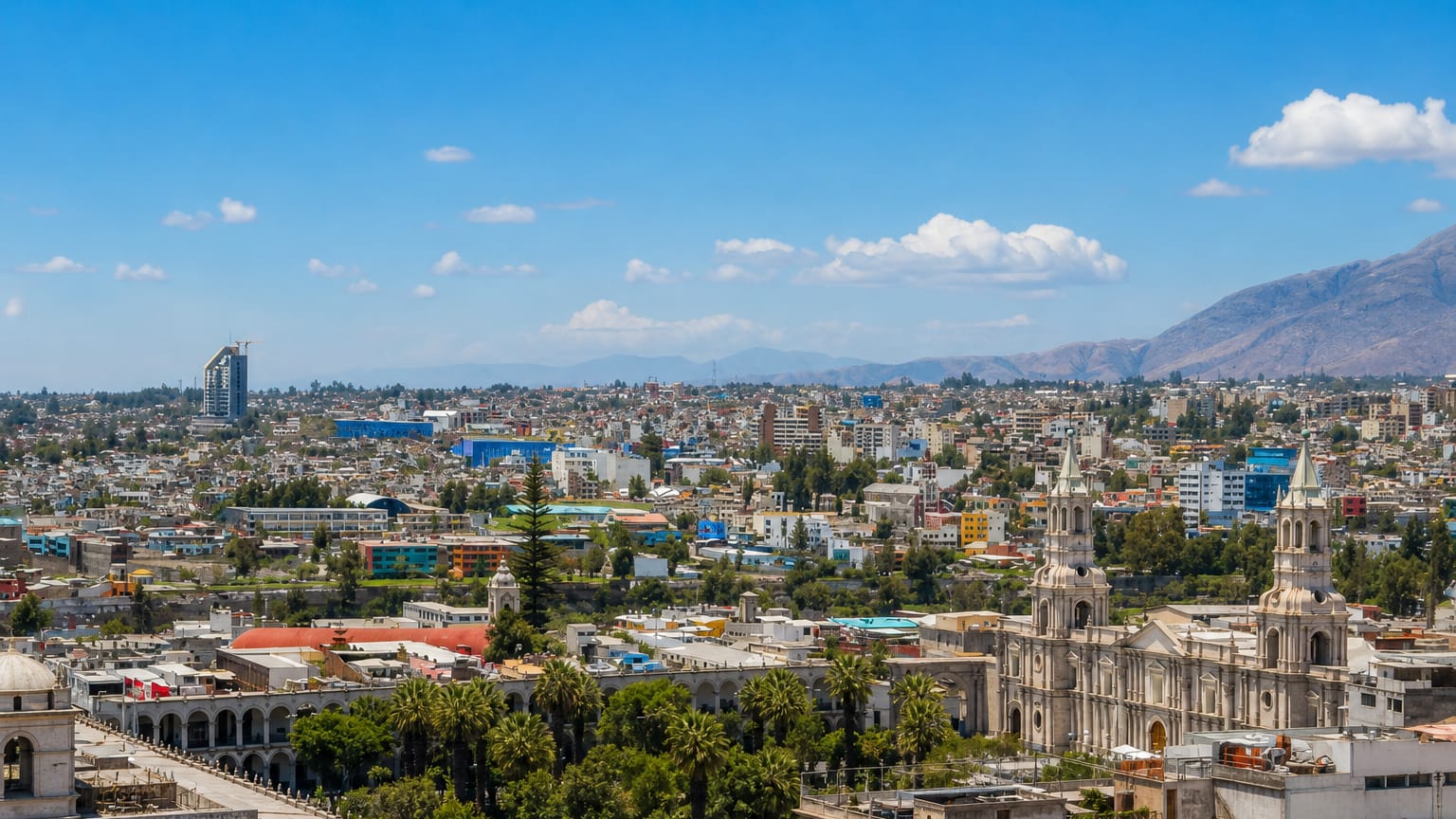 Skyline of Arequipa, Peru, with the twin-towered basilica cathedral and white buildings below the mountains.