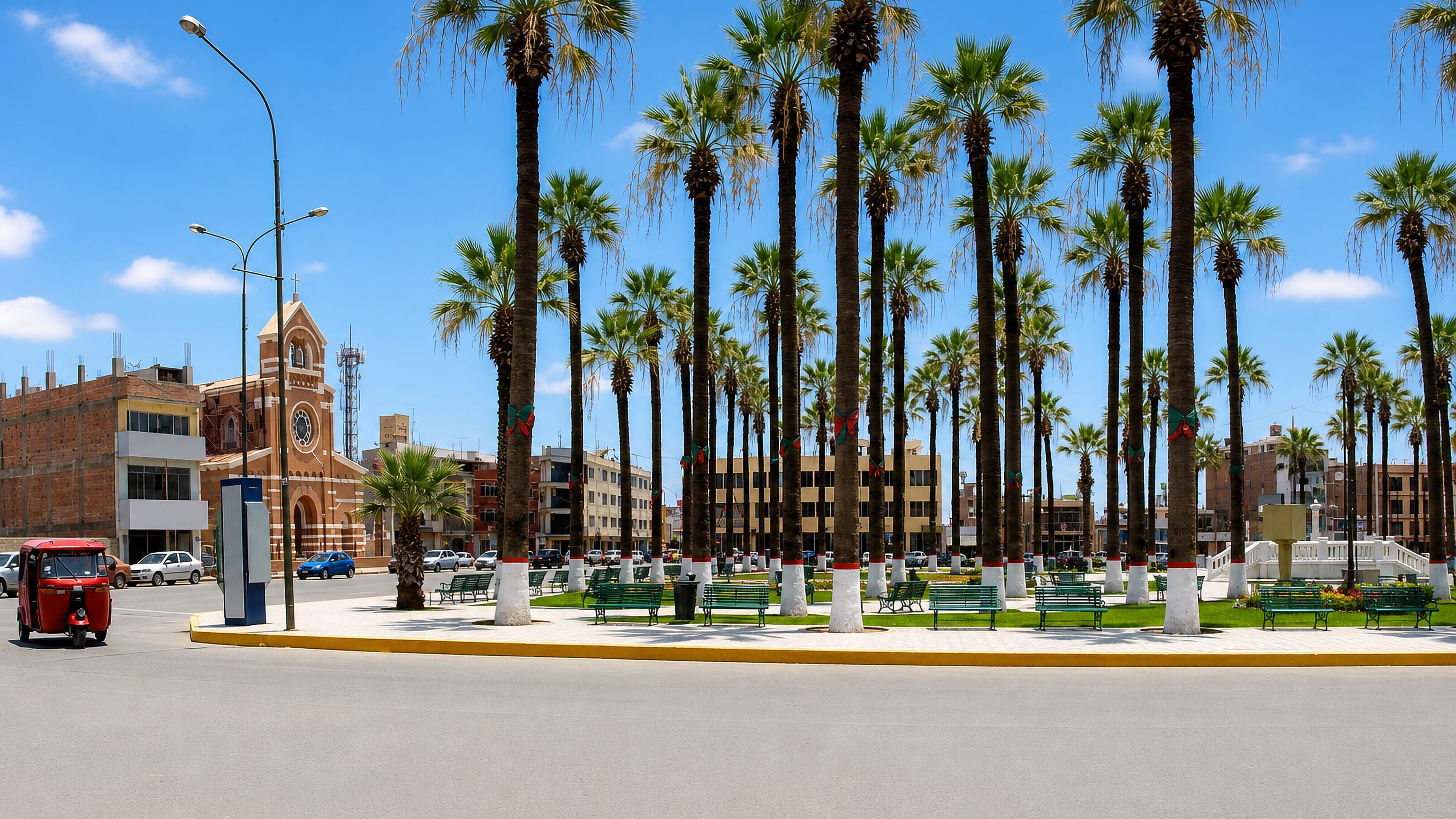 Tall palms and the brick church tower on the plaza at Chincha Alta, with a mototaxi passing.