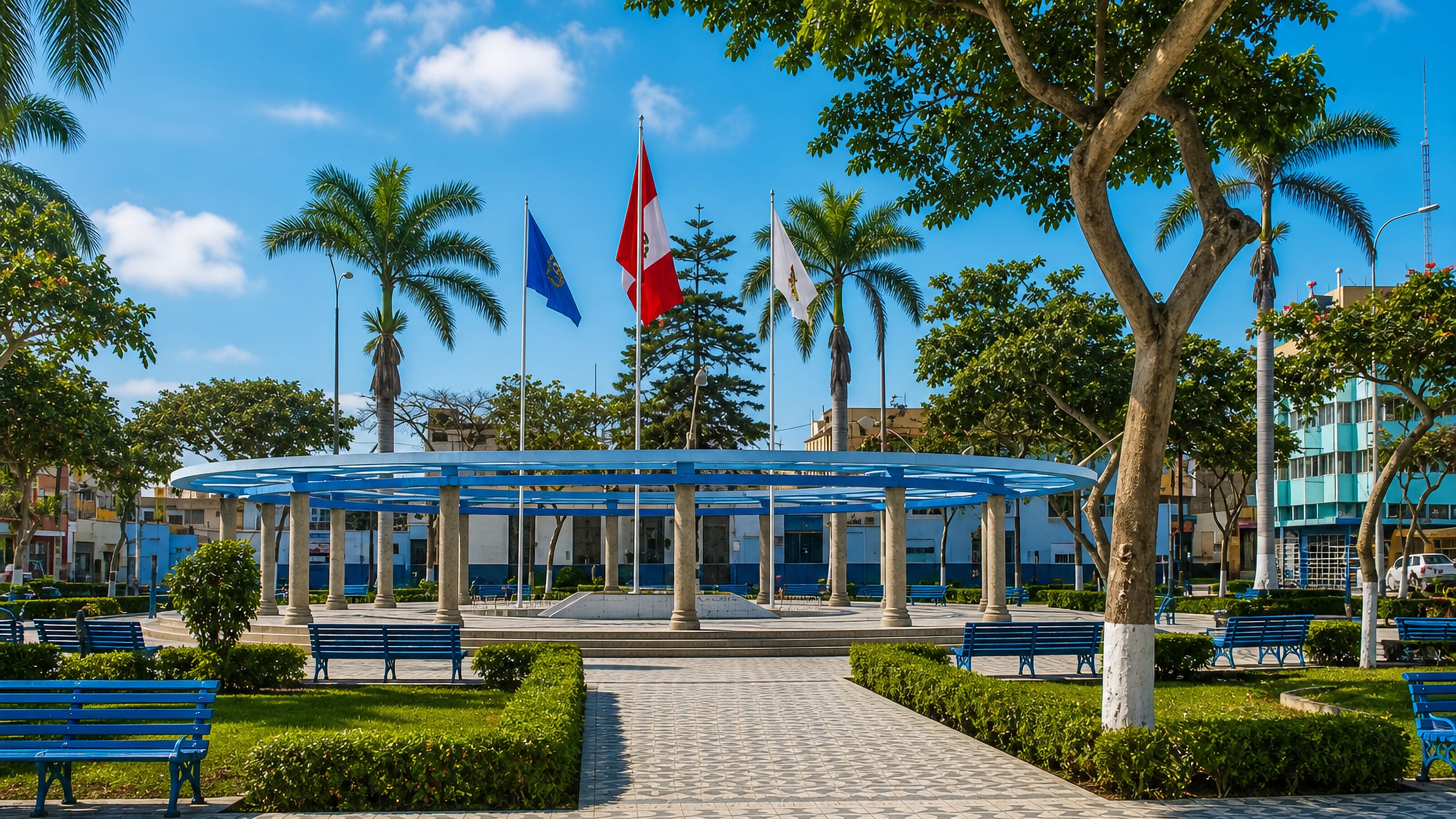 Blue colonnaded pavilion, palms and Peruvian flags on the main plaza of Huacho, Peru.