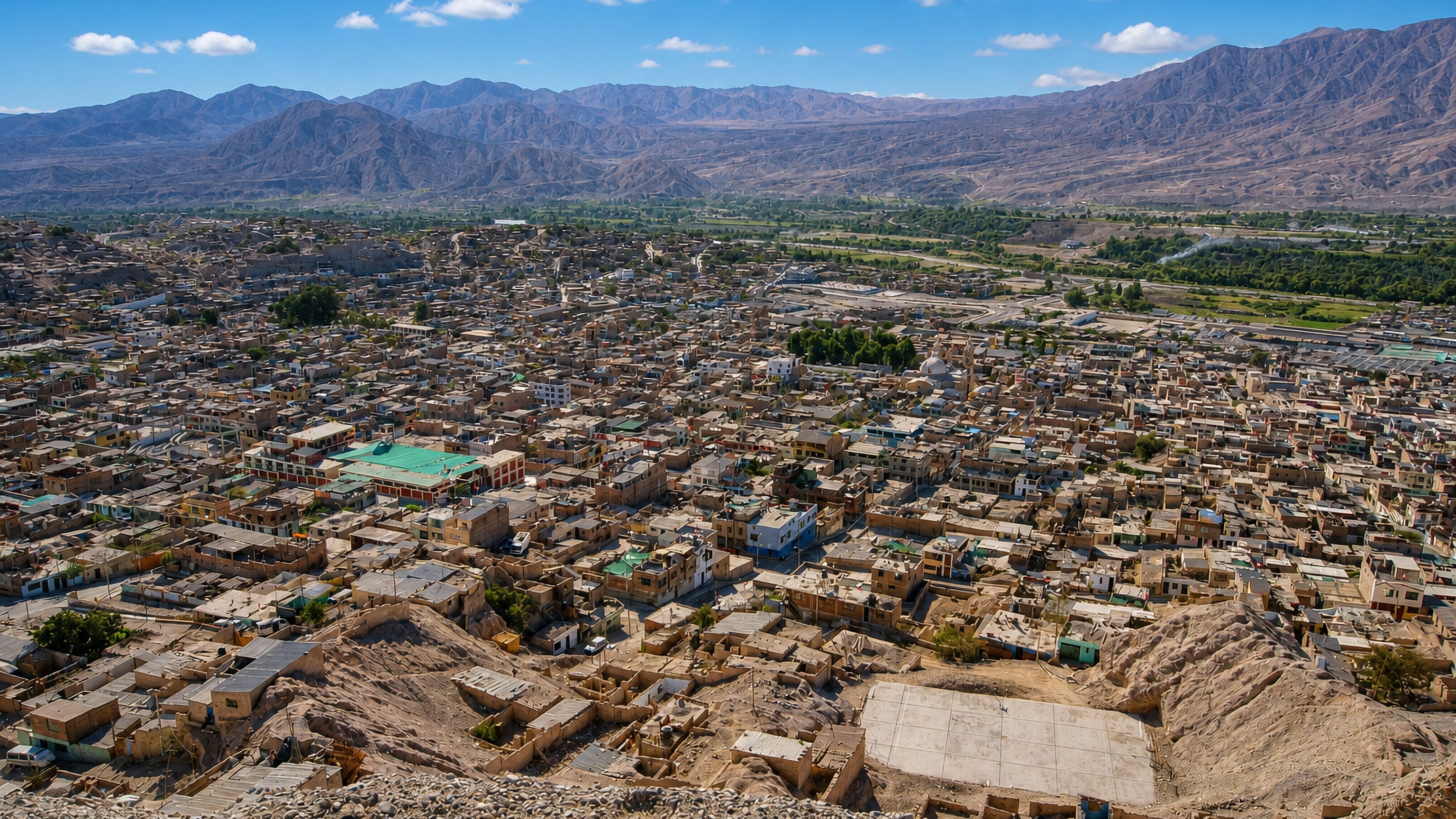 Hillside view over Moquegua, Peru, dense adobe houses filling the valley beneath arid mountains.