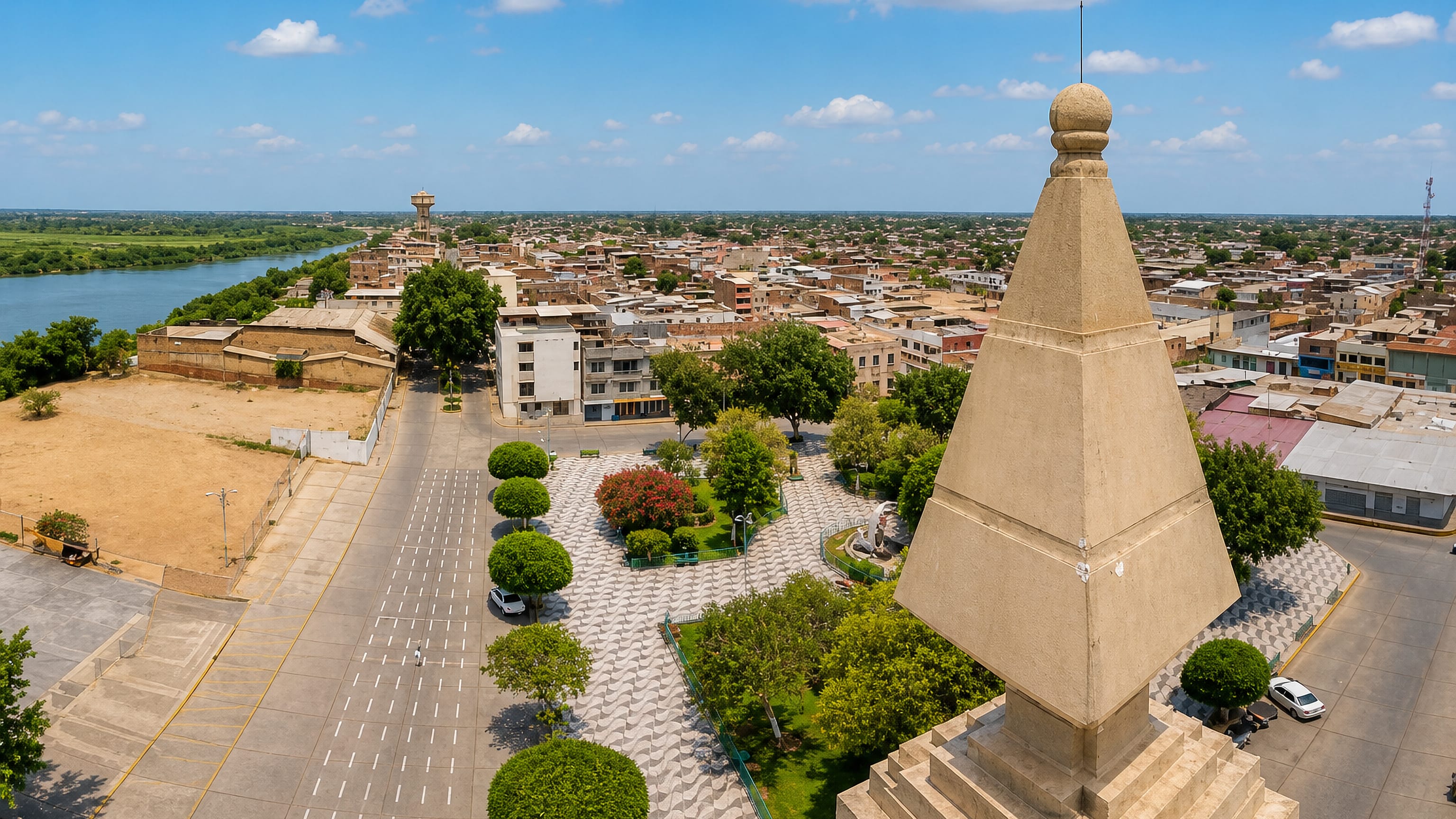 Sullana, Peru, seen from a monument above its tree-lined plaza, with the Chira River beyond.