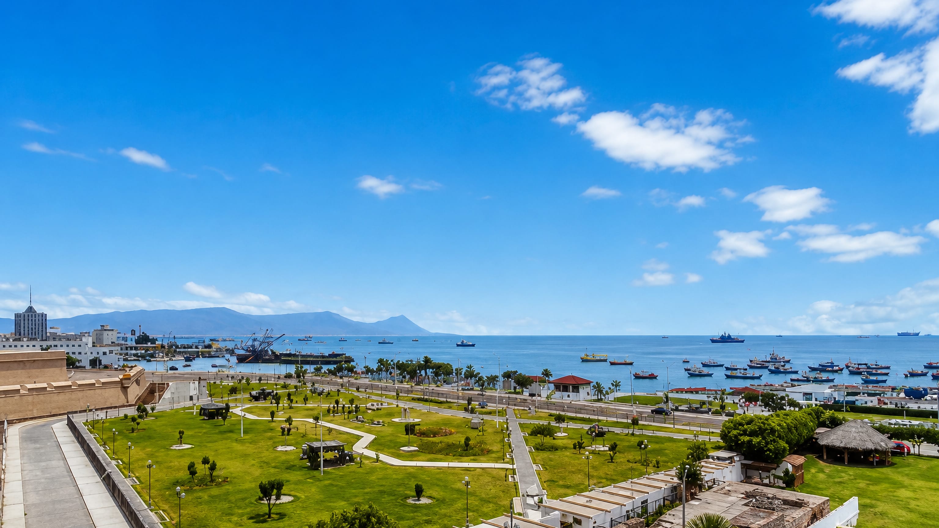 Callao, Peru, seen from the Real Felipe fortress ramparts over a green plaza to the fishing fleet in the bay.